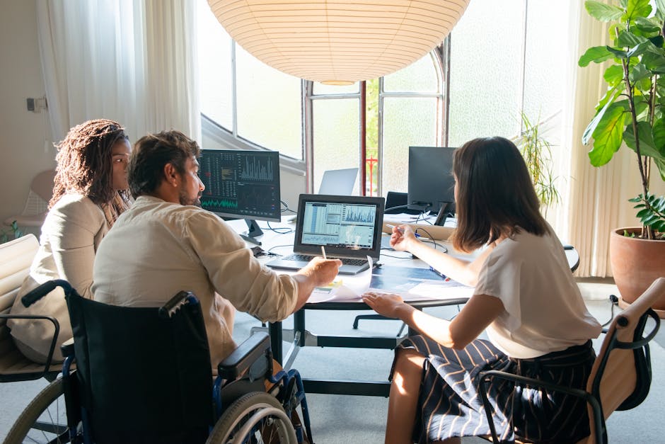 Team of diverse coworkers discussing charts and graphs at a bright, modern office table.